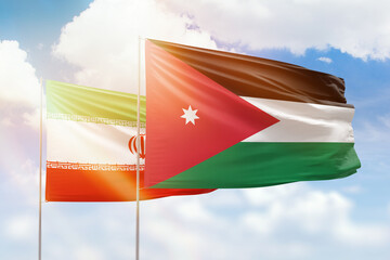 Sunny blue sky and flags of jordan and iran