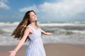 Healthy woman standing on the beach. Freedom girl dancing and daydreaming at beach during summer vacation.