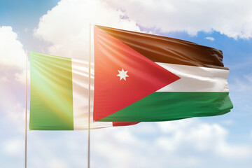 Sunny blue sky and flags of jordan and italy