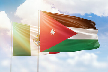 Sunny blue sky and flags of jordan and mexico