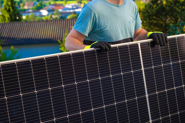 Solar panel in the hands of a worker in a summer garden. Fitting and installation of solar...
