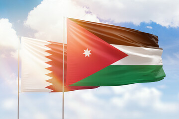 Sunny blue sky and flags of jordan and qatar