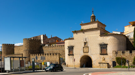 Fototapeta premium View of Puerta de Trujillo, medieval brick building in city wall of Plasencia used as gate to old district and as Catholic chapel on sunny spring day. Historical monument of Spain