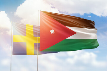 Sunny blue sky and flags of jordan and sweden