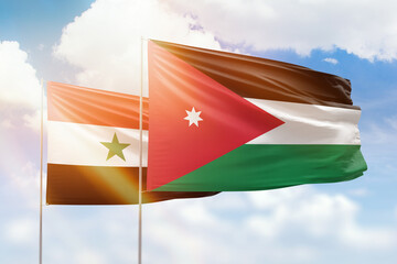 Sunny blue sky and flags of jordan and syria