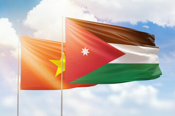 Sunny blue sky and flags of jordan and vietnam