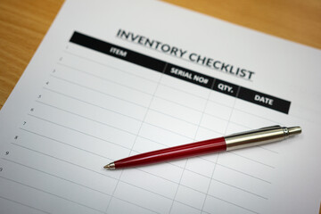 A luxury ballpoint pen is placed on blank form of inventory checklist table, using for checking goods in the factory storage. Business and object working concept. Selective focus.