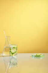 Front view of bitter melon decorated with laboratory equipment in yellow background 