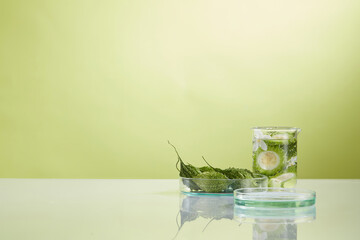 Front view of bitter melon  decorated with laboratory equipment in green background 