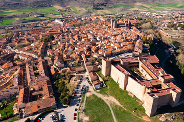 Obraz premium Scenic drone view of ancient reconstructed fortified episcopal castle on hilltop above residential areas of Siguenza town in province of Guadalajara on sunny spring day, Spain