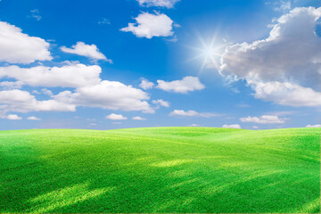 green field and blue sky with light clouds,Image of green grass field and bright blue sky. Plain landscape background for summer poster. The best view for holiday.