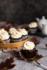 Delicious chocolate cupcake with a cream cap and orange sprinkles. Autumn dish