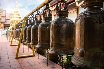 Fila de campanas de bronce de templo buditsta, en Chiang Mai, Tailandia