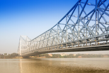 Famous Howrah Bridge connecting Howrah and Kolkata, a propped cantilever bridge with a suspended span over the Hooghly River in West Bengal, India. Commissioned in 1943. A busy symbol of Kolkata.