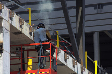 Naklejka premium worker on construction site welding structure concrete building man at work