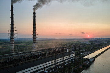 Aerial view of coal power plant high pipes with black smokestack polluting atmosphere. Electricity production with fossil fuel concept