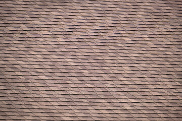 Closeup of house roof top covered with asphalt or bitumen shingles. Waterproofing of new building