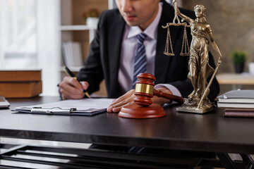 Male lawyer working with contract papers and wooden gavel on table in the courtroom. justice and law, attorney, court judge, concept.