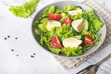 green salad with mozzarella on gray stone background