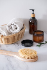 Massage wooden body brush on the background of body cosmetics
