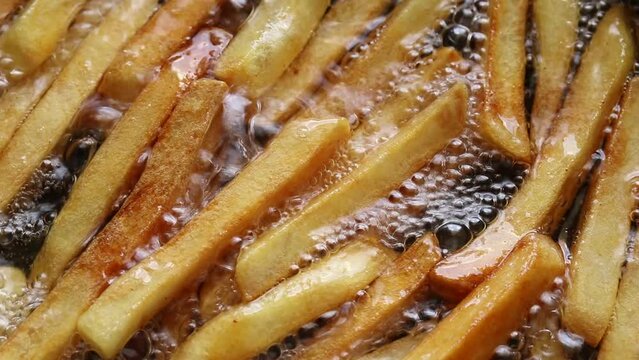 Top view of French fries are fried in boiling oil