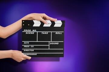 Classic movie slate or clapper board. Hand holds empty film making clapperboard on color background