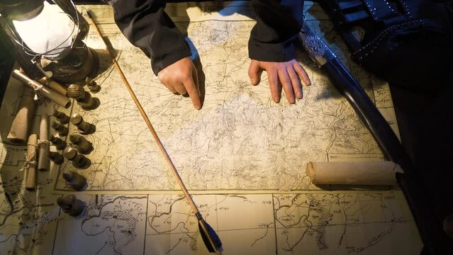 Preparation for war in antiquity.
Planning and strategy development.The commander following the directions with his hands on the map. World history.
