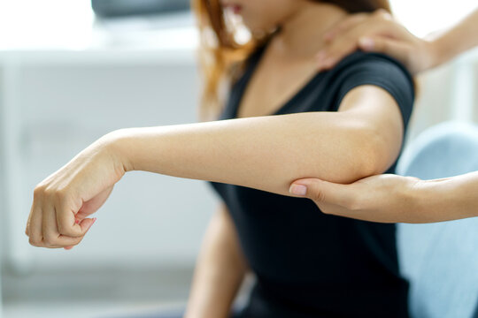 Asian Woman Physiotherapist Oversees The Patient’s Exercise.