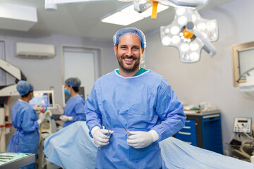 Portrait of male surgeon in operation theater looking at camera. Doctor in scrubs and medical mask...