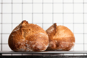 The process of making wheat bread at home. Finished bread cools down after baking. The concept of healthy homemade food. Front view.