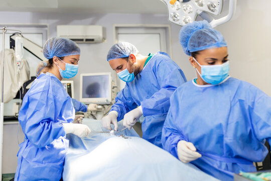 surgeons performing surgery. Doctors are monitoring patient in operating room. They are in hospital.