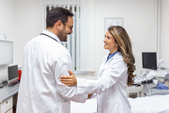 Two Professional confident doctor shaking hands while standing at the clinic .Teamwork of caucasian medical meeting and greeting by handshake at hospital .Medical team, health care concept.