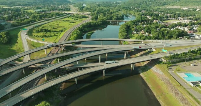 Summer afternoon aerial view of Binghamton New York, upstate NY, where Interstate 81, 86, and US 17 intersect via roadway flyovers, ramps, and bridges.
