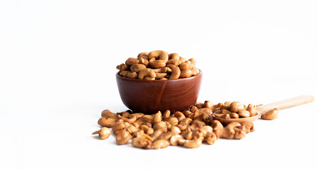 Raw cashews in wooden bowl on sackcloth isolated on white background. Selective focus.