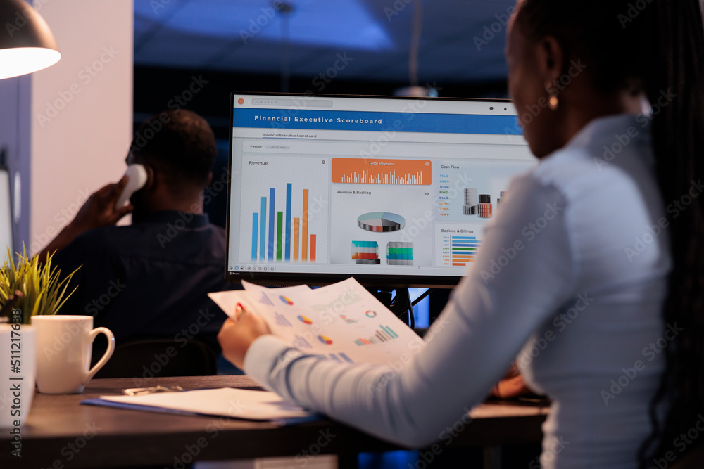 Poster young businesswoman working with statistics charts on computer monitor, analyzing company data on pa