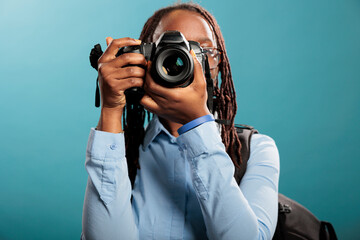 African american young adult photography entusiast with modern photographing device taking photos...