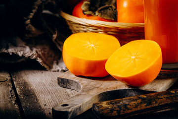 A group of ripe orange persimmon fruits.Persimmon fruits on a wooden board, rustic background