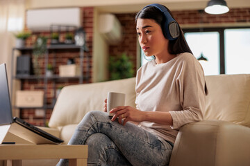 Asian woman at home watching online movie streaming subscription platform, entertainment film...