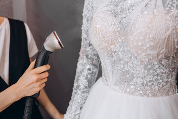 Women Ironing wedding dress in studio by Ironing machine. Wedding concept.
