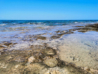 The coast of the Mediterranean Sea, long frozen lava, in the recesses of which there is sea water...