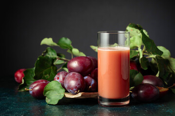 Plum juice and fresh purple plums.