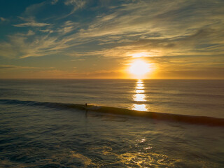 Fototapeta na wymiar Solo surfer at sunrise