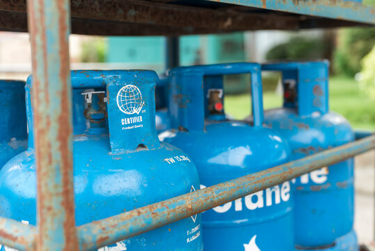 Tagbilaran City, Bohol, Philippines - May 2022: Solane LPG containers in a metal cage to prevent theft. Liquified Petroleum Gas contained in blue cylindrical tanks for sale.