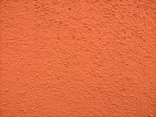 Orange colored grainy cement textured background.