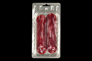 Front view of sliced smoked meat salami in vacuum package isolated on black background. Raw smoked...