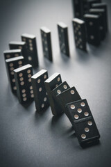 Black dominoes chain on table background