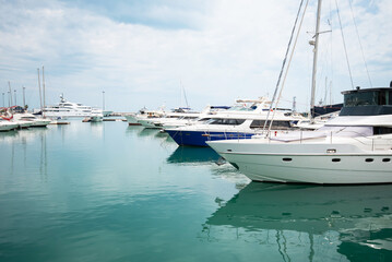 Luxury yachts docked in sea port. Marine parking of modern motor boats and azure water....