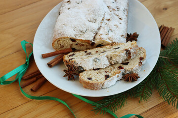 Traditional german sweet bread with raisins and candied fruits called Stollen on a plate on wooden...