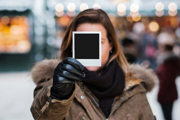 junge Frau hält Polaroid Foto in der Hand - obrazy, fototapety, plakaty
