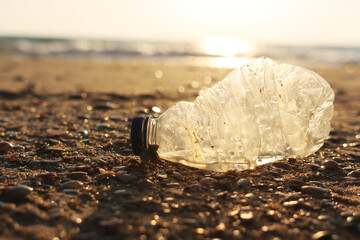 Plastic bottle thrown on the beach . Concept of environmental pollution and damage to nature and animals